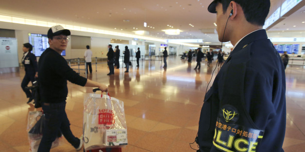 An officer from the anti-terrorism unit of Japan's Metropolitan Police Department keeps guard on the arrival lobby of the international terminal at Haneda Airport in Tokyo Monday, Feb. 2, 2015. Appalled and saddened by news of Japanese hostage Kenji Goto's death following the release of a video showing his killing, purportedly by the Islamic State group, Japan has ordered heightened security precautions at airports and at Japanese facilities overseas, such as embassies and schools. (AP Photo/Koj