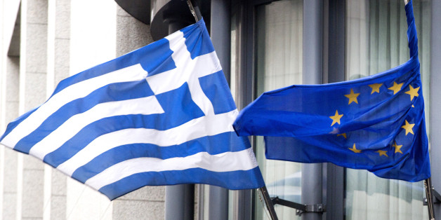 The Greek, left, and EU flag flap in the wind outside the Greek embassy in Brussels on Friday, Feb. 20, 2015. Eurozone finance ministers meet for a crucial day of talks to see whether a Greek debt relief proposal is acceptable to Germany and other nations using the common currency. (AP Photo/Virginia Mayo)