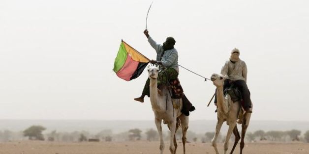 Un touareg brandit le drapeau du Mouvement national de libération de l'Azawad (MNLA) lors d'une manifestation à Kidal, dans le nord du Mali, le 28 juillet 2013