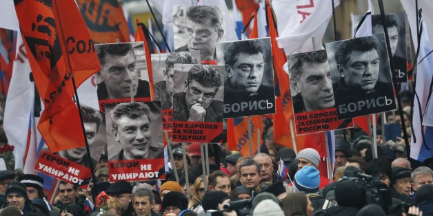 People march in memory of opposition leader Boris Nemtsov, who was gunned down on Friday, Feb. 27, 2015, with portraits of him and words read ' he died for the future of Russia, heroes never die!', near the Kremlin in Moscow, Russia, Sunday, March 1, 2015. Russian investigators, politicians and political commentators on state television on Saturday covered much ground in looking for the reason Nemtsov was gunned down in the heart of Moscow, but they sidestepped one possibility, that he was murde