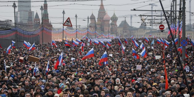 People carry Russian national flags during a march in memory of opposition leader Boris Nemtsov who was gunned down on Friday, Feb. 27, 2015 near the Kremlin, with The Kremlin Wall and St. Basil Cathedral in the background in Moscow, Russia, Sunday, March 1, 2015. Thousands converged Sunday in central Moscow to mourn veteran liberal politician Boris Nemtsov, whose killing on the streets of the capital has shaken Russiaâs beleaguered opposition. They carried flowers, portraits and white sig