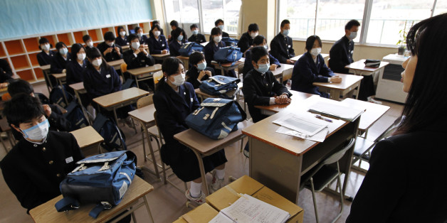 A teacher explains the process of a ceremony for the first day of the new school year in Kesennuma, Miyagi Prefecture, northeastern Japan, Thursday, April 21, 2011. The gymnasium of the school is used for an evacuation center for those who lost houses in the March 11 earthquake and tsunami. (AP Photo/Hiro Komae)