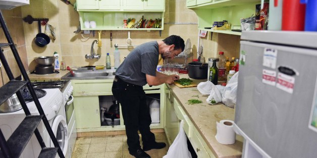 In this Feb. 25, 2015 photo, Adel bin Muhammad El Ouerghi, from Tunisia, chops parsley in the home he shares with five other former Guantanamo detainees in Montevideo, Uruguay. El Ouerghi said he wants to open an Arab restaurant that would serve shwarma, kebobs and other traditional Middle Eastern foods, which he hasn't found in Montevideo. (AP Photo/Matilde Campodonico)