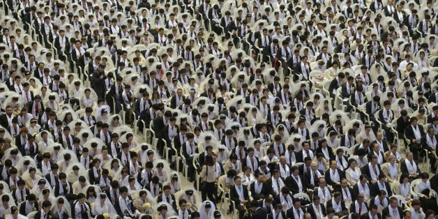 Couples attend a mass wedding held by the Unification Church in Gapyeong on March 3, 2015. Hundreds of couples were married at the South Korean headquarters of the Unification Church --- the third such event since the death of church founder Sun Myung Moon. AFP PHOTO / ED JONES (Photo credit should read ED JONES/AFP/Getty Images)