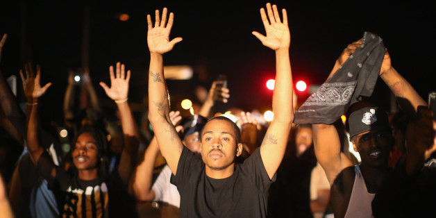FERGUSON, MO - AUGUST 12: Demonstrators protest the killing of teenager Michael Brown on August 12, 2014 in Ferguson, Missouri. Brown was shot and killed by a police officer on Saturday in the St. Louis suburb of Ferguson. Ferguson has experienced two days of violent protests since the killing but, tonight's protest was peaceful. (Photo by Scott Olson/Getty Images)