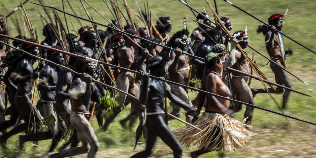 WAMENA, INDONESIA - AUGUST 08: The Papuanese tribes perform mock battles in an open field during the 25th Baliem Valley festival on August 8, 2014 in Wamena, Indonesia. The Baliem Valley Cultural Festival has been organized annually in the Baliem Valley, home to three Papua interior tribes: the Dani, Lani and Yali tribes. Every year these three tribes gather together at their annual Baliem valley festival dressed in distinctive tribal attire, stage mock battles, perform traditional music and dan