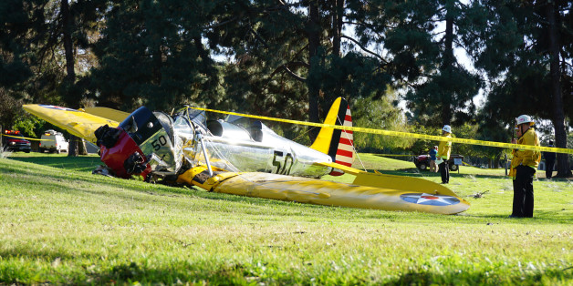 Officials work on the scene of a vintage airplane that crash-landed on the Penmar Golf Course in the Venice area of Los Angeles, Thursday, March 5, 2015. Harrison Ford crash-landed the airplane shortly after taking off from a nearby airport and reporting engine problems. (AP Photo/Damian Dovarganes)
