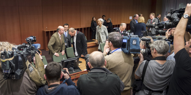 Greek Finance Minister Yanis Varoufakis, rear center right, speaks with Spanish Economy Minister Luis de Guindos, rear center left, as they are filmed during a round table meeting of eurogroup finance ministers in Brussels on Friday, Feb. 20, 2015. Eurozone finance ministers meet for a crucial day of talks Friday to see whether a Greek debt relief proposal is acceptable to Germany and other nations using the common currency. (AP Photo/Geert Vanden Wijngaert)
