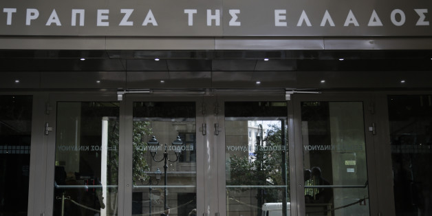 People walk past the Bank of Greece headquarters, in central Athens, on Friday, March 6, 2015 . European Central Bank head Mario Draghi said the ECB "stood ready" to once again permit Greek banks to use junk-rated Greek government bonds as collateral to get credit from the ECB. That would happen as soon as the bank assesses that Greece is likely to successfully complete a creditor review of its progress. (AP Photo/Petros Giannakouris)