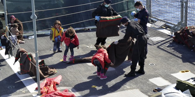 In this photo taken on Saturday, Nov. 15, 2014 and provided by the Portoguese Navy, sailors and children fold blankets on the dock of the Portoguese Navy vessel Viana do Castelo. The Portuguese open sea patrol vessel the Viana Do Castelo made its first rescue of migrants as part of Operation Triton, the EU operation that has stepped in to help Italy patrol its coastline. A spokeswoman for Frontex, the European Agency that coordinates Triton deployment, told the Associated Press that in recent days Operation Triton has rescued over 600 migrants. The European Operation Triton is taking over from the Italian Operation Mare Nostrum which was launched by the Italian government in October of 2013, following a migrant shipwreck that left over 300 people dead just off the coast of Lampedusa, the small strip of island that is part of Italy but closer to the African mainland. (AP Photo/Portuguese Navy, ho)