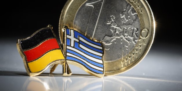 BERLIN, GERMANY - FEBRUARY 10: Symbolic photo of Greece and the Euro, one euro coin behind a badge with the national flags of Greece and Germany on February 10, 2015 in Berlin, Germany. (Photo by Thomas Trutschel/Photothek via Getty Images)
