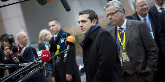 Greek Prime Minister Alexis Tsipras, center, speaks with the media as he arrives for an EU summit in Brussels on Thursday, Feb. 12, 2015. European Union leaders on Thursday said the full respect of the planned weekend cease-fire in eastern Ukraine will be essential before there could be a change in the sanctions regime imposed on Moscow. (AP Photo/Virginia Mayo)