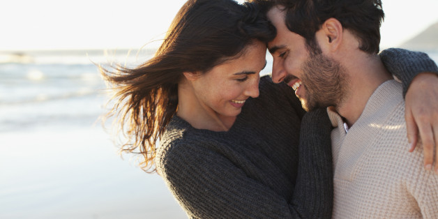 Smiling couple hugging on beach