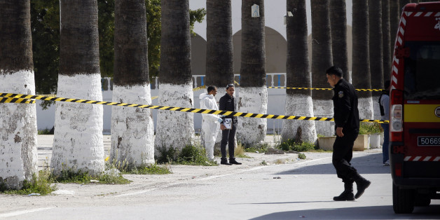 Police officers look for evidence, outside the Bardo museum in Tunis, Tunisia, Thursday, March 19, 2015, a day after gunmen opened fire killing over 20 people, mainly tourists. One of the two gunmen who killed 19 tourists and others at a prominent Tunisian museum was known to intelligence services, Tunisia's prime minister said Thursday. But no formal links to a particular terrorist group have been established in an attack that threatens the country's fledgling democracy and struggling tourism industry. (AP Photo/Christophe Ena)
