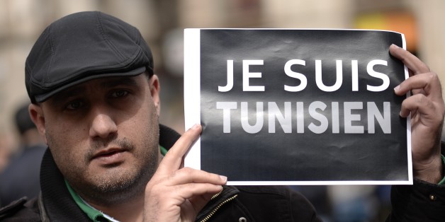 A Tunisan holds up a sign reading, ' I am Tunisian', during a minute of silence held outside Barcelona's city hall in Barcelona on March 19, 2015 for Spanish victims of a gunmen attack at the Bardo National Museum in the Tunisian capital Tunis that left 21 dead. Nine people suspected of links with the gunmen who attacked the museum have been arrested, the presidency announced today. AFP PHOTO / JOSEP LAGO (Photo credit should read JOSEP LAGO/AFP/Getty Images)