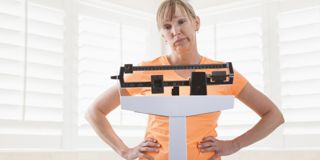 Caucasian woman weighing herself