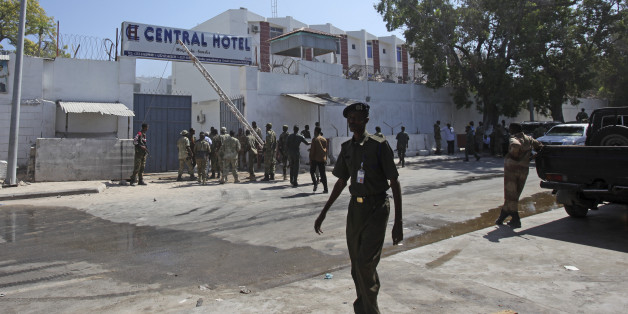 Somali security forces gather outside the scene of a twin bombing attack on a hotel in the capital Mogadishu, Somalia Friday, Feb. 20, 2015. One person rammed an explosives-laden vehicle into the gate of the Central Hotel in Somalia's capital, and another went through the gates and blew himself up, killing at least four people on Friday including the deputy mayor and a legislator, officials said, while the country's deputy prime minister was also among those wounded by the bombings. (AP Photo/Farah Abdi Warsameh)