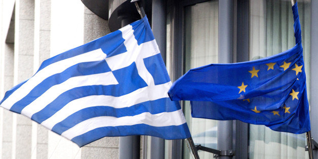 The Greek, left, and EU flag flap in the wind outside the Greek embassy in Brussels on Friday, Feb. 20, 2015. Eurozone finance ministers meet for a crucial day of talks to see whether a Greek debt relief proposal is acceptable to Germany and other nations using the common currency. (AP Photo/Virginia Mayo)