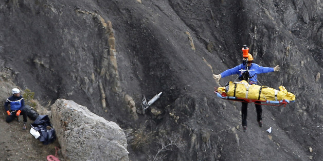 FILE - In this Thursday March 26, 2015 file photo a rescue worker is lifted into an helicopter at the crash site near near Seyne-les-Alpes, France. The somber mission to recover the remains of 150 people killed instantly when the Germanwings flight slammed full speed into the Col de Mariaud is not a quiet one and crucial physical evidence for the crash investigation can be gathered only when the mountains cooperate. (AP Photo/Laurent Cipriani, File)