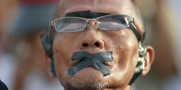 A protester displays how his rights were violated during an anti-coup demonstration at the Victory Monument in Bangkok, Thailand Wednesday, May 28, 2014. Thailand's new military junta aired videos Wednesday on television stations nationwide showing some of the prominent political figures it has detained as part of an effort to convince the public that detainees in army custody are being treated well. (AP Photo/Wason Wanichakorn)