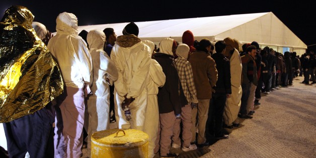 Rescued migrants line up after disembarking from an Italian Coast Guard ship in the harbor of Augusta, Sicily, southern Italy, Wednesday, March 4, 2015. In a dramatic sea rescue north of Libya, a flotilla of rescue ships saved nearly 1,000 migrants and refugees, while 10 migrants perished in the southern Mediterranean, Italian officials said Wednesday. The rescue vessels, including from Italy's coast guard and navy, and three cargo ships, saved 941 people in seven separate operations that began