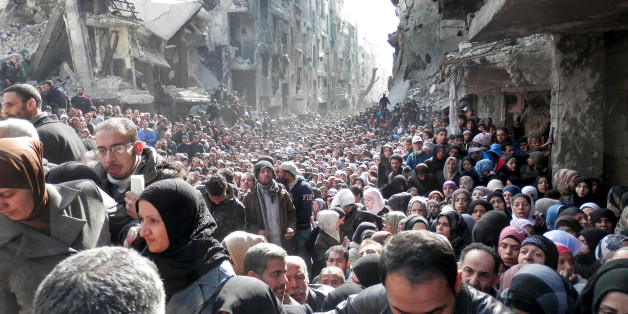 FILE - This picture taken on Jan. 31, 2014, and released by the United Nations Relief and Works Agency for Palestine Refugees (UNRWA), shows residents of the besieged Palestinian camp of Yarmouk, queuing to receive food supplies, in Damascus, Syria. On Wednesday, April. 1, 2015 Islamic State militants infiltrated the Palestinian refugee camp of Yarmouk in the Syrian capital marking the deepest foray yet by the extremist group into Damascus, seat of President Bashar Assadâs power, Syrian opposition activists and Palestinian officials said. (AP Photo/UNRWA, File)