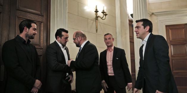Greek Prime Minister Alexis Tsipras, right, looks on as European Parliament President Martin Schulz, center, shakes hands and talks with Greek Minister of State Nikos Pappas, second left, following a news conference after their meeting at Maximos Mansion in Athens, Thursday, Jan. 29, 2015. Schulz is the first European Union official to meet Tsipras, whose new Cabinet alarmed the Greek stock market Wednesday with promises to renege on a series of key budget commitments made by previous administra