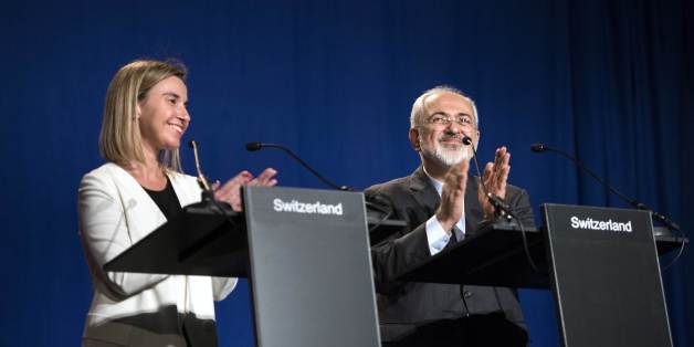 Iranian Foreign Minister Javad Zarif, right, claps with European Union High Representative for Foreign Affairs and Security Policy Federica Mogherini, after making a statement at the Swiss Federal Institute of Technology, or Ecole Polytechnique Federale De Lausanne, in Lausanne, Switzerland, Thursday, April 2, 2015, after Iran nuclear program talks finished with extended sessions. The United States, Iran and five other world powers on Thursday announced an understanding outlining limits on Iran