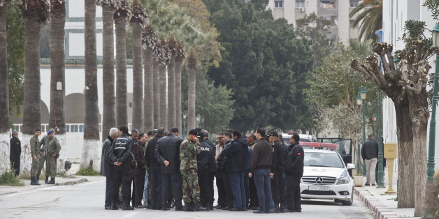 Tunisian police and defense officials gather outside the National Bardo museum in Tunis, Tunisia, Saturday March 21, 2015. The two extremist gunmen who killed 21 people at a museum in Tunis trained in neighboring Libya before caring out the deadly attack, a top Tunisian security official said. (AP Photo/Michel Euler)