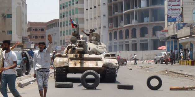 Militiamen loyal to Yemen's President Abed Rabbo Mansour Hadi take positions at a street in Aden, Yemen, Thursday, April 2, 2015. Yemen's Shiite rebels and their allies fought their way through the commercial center of Aden on Thursday and seized the presidential palace on a strategic hilltop in this southern coastal city, security officials said. (AP Photo/Wael Qubady)