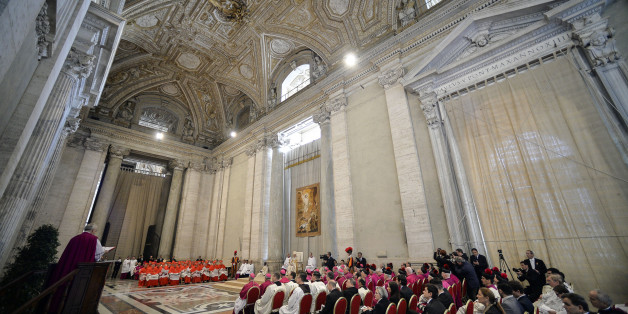 Pope Francis, left, speaks in St. Peter's Basilica, at the Vatican, Saturday, April 11, 2015. Pope Francis has proclaimed a special year of efforts by the Catholic Church to be more merciful and less judgmental. At St. Peter's Basilica Saturday evening, he listened as a Vatican prelate read excerpts from a papal bull, or decree, in which Francis proclaimed an "Extraordinary Jubilee of Mercy" Holy Year. The year begins on Dec. 8 with Francis' opening the normally closed Holy Door in the back of t