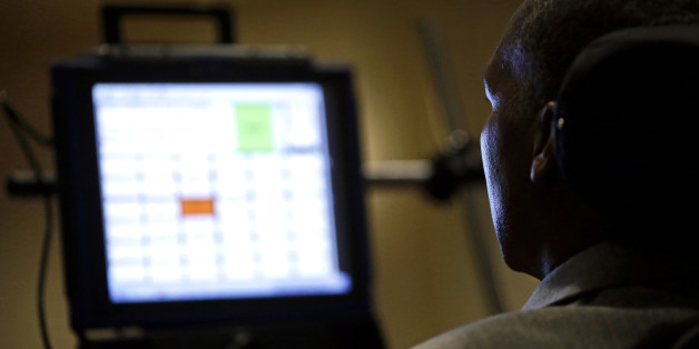 Light from a computer screen reflects off of the face of O.J. Brigance, a former Baltimore Ravens football player and current senior advisor to player development, as he testifies to Maryland lawmakers against a right-to-die bill, Tuesday, March 10, 2015, in Annapolis, Md. Brigance was diagnosed with Lou Gehrig's disease, which has no cure, in May 2007, and the computer helps him to communicate. The measure would allow adults given only six months to live the ability to get a prescription for drugs to hasten their death. (AP Photo/Patrick Semansky)