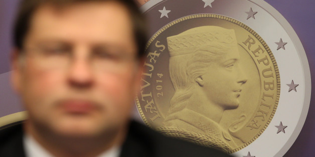 A reproduction of a Latvian euro coin is displayed, as Latvian Prime Minister Valdis Dombrovskis addresses the media on the adoption of the euro, at the European Council building in Brussels, Tuesday, July 9, 2013. European finance ministers are welcoming Latvia's upcoming adoption of the euro currency as a bright spot of progress amid the wider economic gloom. (AP Photo/Yves Logghe)