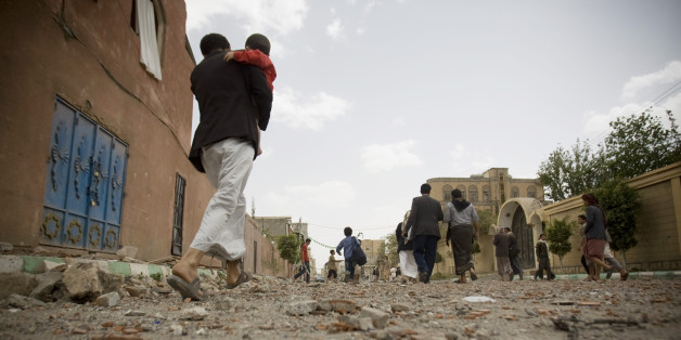 FILE - In this Wednesday, April 8, 2015 file photo, people flee after a Saudi-led airstrike in Sanaa, Yemen. A state-run broadcaster in Iran is reporting that the Islamic Republic has sent a navy destroyer and another vessel to waters near Yemen amid a Saudi-led airstrike campaign. (AP Photo/Hani Mohammed, File)