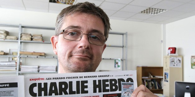 FILE - In this Sept.19, 2012 file photo, Stephane Charbonnier also known as Charb , the publishing director of the satyric weekly Charlie Hebdo, displays the front page of the newspaper as he poses for photographers in Paris. The late former editor of French weekly Charlie Hebdo takes on politicians, the media and "Islamophobia" as thinly veiled racism in a posthumously published book that was completed two days before he died in France's worst terror attack in years. (AP Photo/Michel Euler, Fil