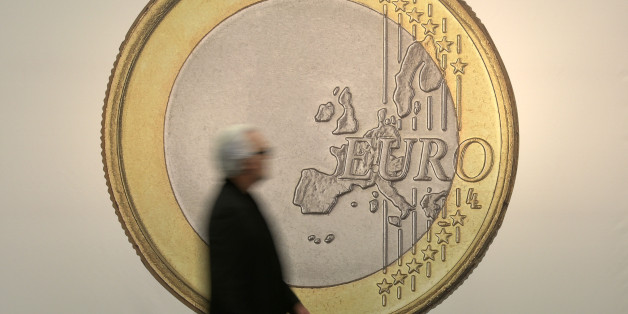 A man passes the artwork "Euro" by artist group Superflex at the art fair in Cologne, Germany, Thursday, April 16, 2015. (AP Photo/Martin Meissner)