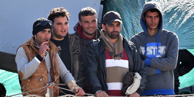 Migrants stand on the deck of the Italian Navy ship "Driade" prior to being disembarked in Messina's port, Sicily, Italy, Saturday, April 18, 2015. Italian ships have picked up some 10,000 people, many of them refugees of war and persecution, over the past week, an unprecedented number in such a short period. The influx is putting pressure on Italy's shelter system and raising calls for a better response to the emergency. (AP Photo/Carmelo Imbesi)