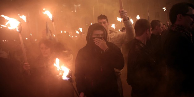 Members of the Greek ultra nationalist party Golden Dawn hold torches on January 31, 2015 during a gathering of Greek nationalists in central Athens, to commemorate the death of three Greek military officers. The crew of a Greek army helicopter crashed on January 31 at open sea in the Imia islets, at the Greek-Turkish sea borders, during a military crisis and subsequent dispute between the two countries over sovereignty of the islets in 1996. AFP PHOTO / ANGELOS TZORTZINIS (Photo credit s