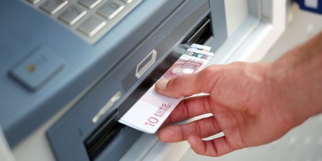 A man takes out Euro banknotes from an automated teller machine (ATM) at a cash point of the French bank 'La Banque Postale' in Carquefou, Western France, on September 10, 2014. AFP PHOTO / JEAN-SEBASTIEN EVRARD (Photo credit should read JEAN-SEBASTIEN EVRARD/AFP/Getty Images)