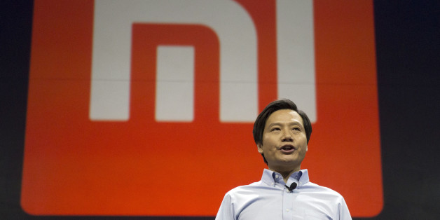 Xiaomi Chairman Lei Jun stands in front of the logo of the Chinese smartphone maker, at a press event in Beijing, Thursday, Jan. 15, 2015. The Chinese manufacturer on Thursday unveiled a new model that Lei said has processor size and performance comparable to Appleâs iPhone 6 but is thinner and lighter. (AP Photo/Ng Han Guan)