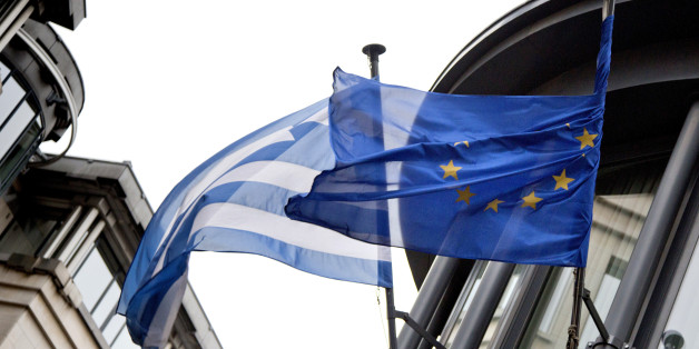 The Greek, left, and EU flag flap in the wind outside the Greek embassy in Brussels on Friday, Feb. 20, 2015. Eurozone finance ministers meet for a crucial day of talks to see whether a Greek debt relief proposal is acceptable to Germany and other nations using the common currency. (AP Photo/Virginia Mayo)