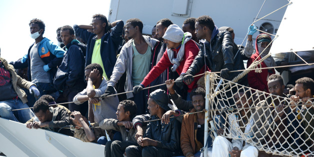 Migrants wait to disembark from the Italian Navy vessel 'Chimera' in the harbor of Salerno, Italy, Wednesday, April 22, 2015. Italy pressed the European Union on Wednesday to devise concrete, robust steps to stop the deadly tide of migrants on smugglers' boats in the Mediterranean, including setting up refugee camps in countries bordering Libya. Italian Defense Minister Roberta Pinotti also said human traffickers must be targeted with military intervention. (AP Photo/Francesco Pecoraro)