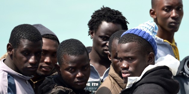 Rescued migrants wait before disembarking off the Italian Guardia Costiera vessel Fiorillo at the Sicilian harbour of Catania on April 24, 2015. Italy's interior ministry is expecting migrant arrivals at Italian ports to run at a rate of 5,000 per week from now until September -- pointing to a total for the year around 200,000, up from last year's record figure of 170,000. AFP PHOTO / ALBERTO PIZZOLI (Photo credit should read ALBERTO PIZZOLI/AFP/Getty Images)