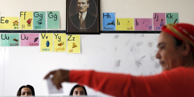 A Turkish Cypriot woman casts her vote in front of a portrait of Mustafa Kemal Ataturk, the founder of modern Turkey, during the second round of the presidential elections on April 26, 2015, at a polling station in the eastern port city of Famagusta, in the self-proclaimed Turkish Republic of Northern Cyprus (TRNC). Voters in the tiny republic, which is only recognised by Turkey, went to the polls to choose a new leader in an election runoff that could speed UN-brokered reunification talks. AFP PHOTO / FLORIAN CHOBLET (Photo credit should read FLORIAN CHOBLET/AFP/Getty Images)