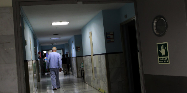 A reading "Hospital unit, beds 3201 to 3240" are seen, as a patient walks down a corridor in a Hospital in Madrid, Spain, Monday, March 25, 2013. The European financial crisis has not only sent stock markets plummeting and driven protesters to the street, but it is also being blamed for health problems across the continent including a spike in suicides and disease outbreaks, according to new research. Since the crisis first struck in 2008, the hardest-hit countries have sharply curtailed their h