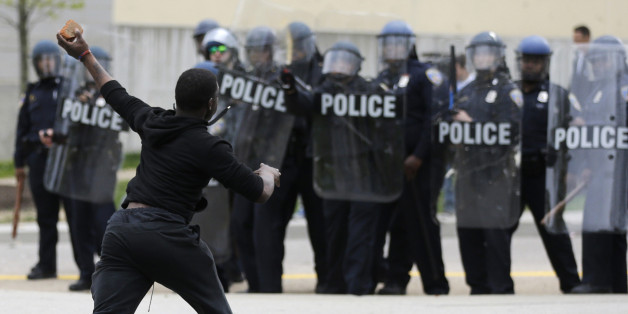 A man throws a brick at police Monday, April 27, 2015, following the funeral of Freddie Gray in Baltimore. (AP Photo/Patrick Semansky)