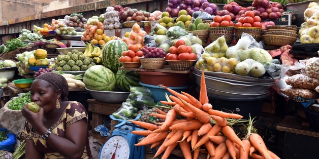 A photo taken on November 6, 2014 shows a fruit and vegetable seller eating an apple in front of her stall at a market in Ouagadougou, Burkina Faso. Burkina Faso's army-appointed leader on November 6 shrugged off a demand by the African Union to return power to a civilian government within two weeks, saying what is more critical is ensuring a smooth transition through elections next year. Lieutenant-Colonel Isaac Zida declared that 'we are not afraid of sanctions' and that stability and peace trumped all, after the country was thrown into turmoil when a violent popular uprising toppled long-running president Blaise Compaore. AFP PHOTO / ISSOUF SANOGO (Photo credit should read ISSOUF SANOGO/AFP/Getty Images)