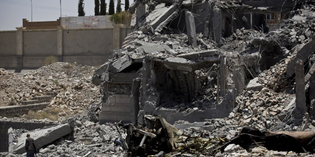 A Shiite fighter, known as a Houthi, bottom left, collects ammunition at the residence of a military commander of the Houthi militant group, destroyed by a Saudi-led airstrike, in Sanaa, Yemen, Tuesday, April 28, 2015. A security official in Saudi Arabia says a soldier has been killed and another wounded in a gunfight with Shiite Houthi rebels along the kingdom's southern border with Yemen. (AP Photo/Hani Mohammed)
