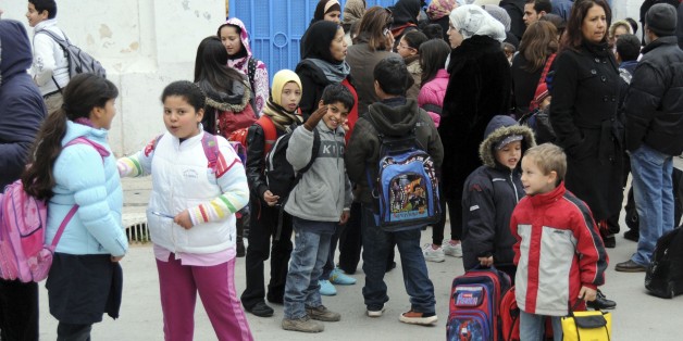 Schoolchildren wait outside their school in Tunis, Monday Jan. 24, 2010. Teachers across Tunisia have gone on strike to demand members of the former party of the ousted president stay out of power, on the day when schools were set to reopen after weeks of closure amid unrest and street protests. (AP Photo/Hassene Dridi)