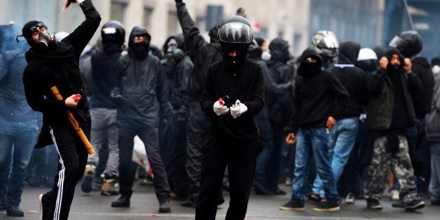 Demonstrators face off against police during a demonstration against Milan's Universal Exposition, EXPO2015, in Milan on May 1, 2015. Italian police clashed with protesters at the Milan Expo on May 1, firing tear gas at the masked demonstrators who had pelted officers with stones. AFP PHOTO / FILIPPO MONTEFORTE (Photo credit should read FILIPPO MONTEFORTE/AFP/Getty Images)